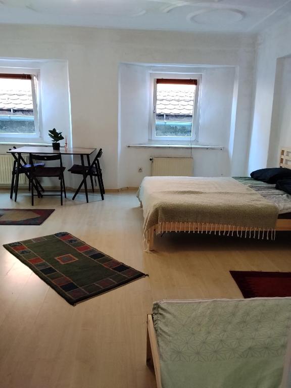 a bedroom with two beds and a table in it at BLR Apartment in Graz