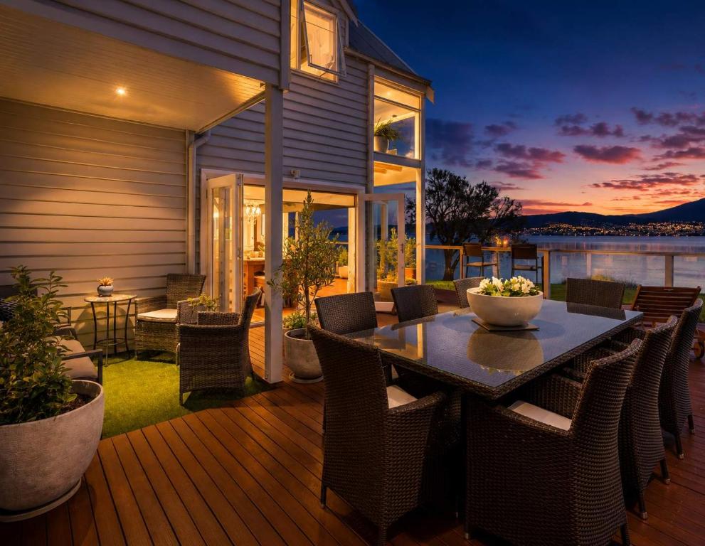 a patio with a table and chairs on a deck at Casa Con Vista Luxury Waterfront Home, Sleeps 10 in Hobart