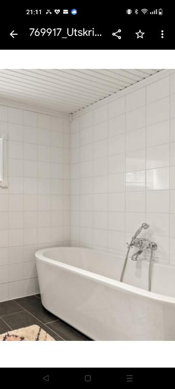 a white bath tub in a bathroom at Et soverom, delt bad in Fredrikstad