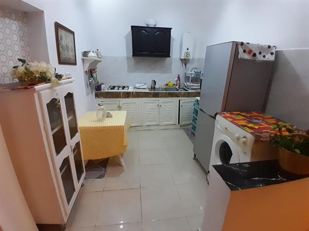 a kitchen with a refrigerator and a sink and a stove at إقامة تسنيم in Selouane
