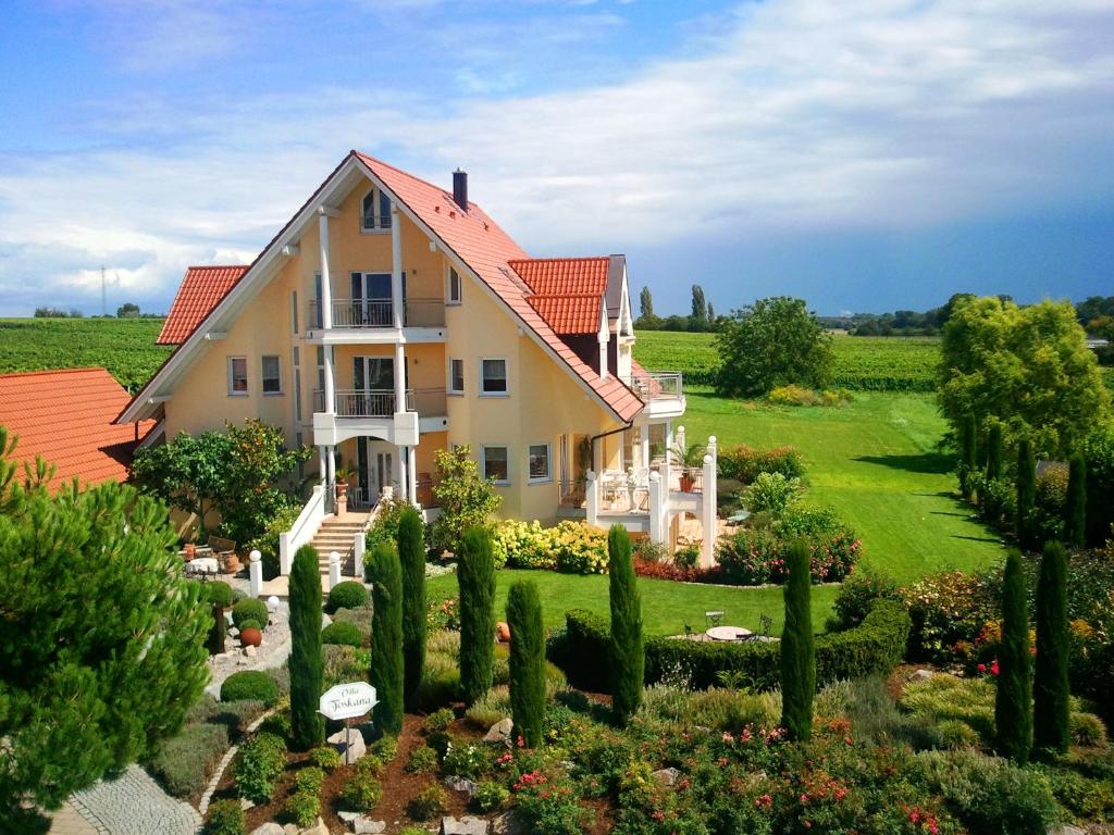 uma casa grande com jardim e árvores em Villa Toskana em Bornheim