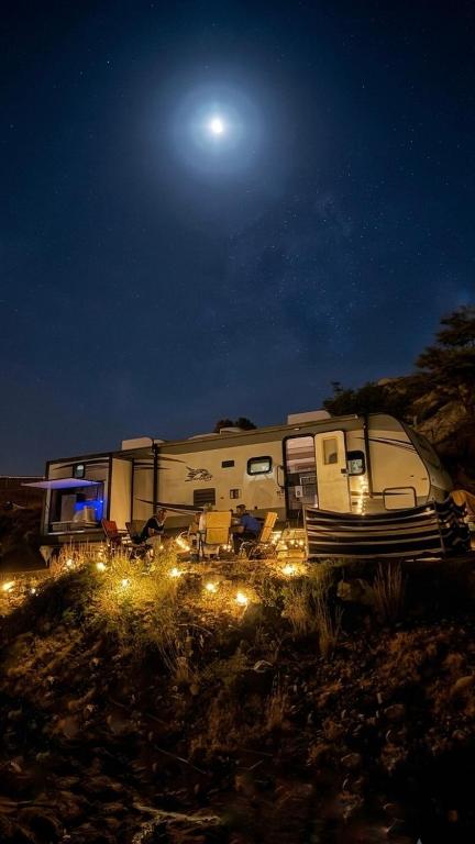 a trailer parked in a field at night at كرفان نور القمر in Al Namas