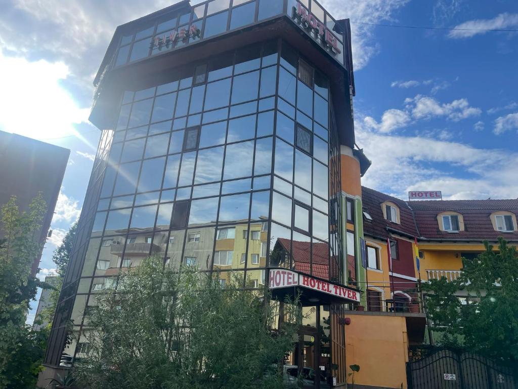 a tall glass building on a city street at Hotel Tiver in Câmpia Turzii