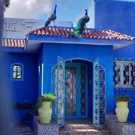 a blue house with three birds sitting on the roof at Propriété La Petite Ferme in Casablanca
