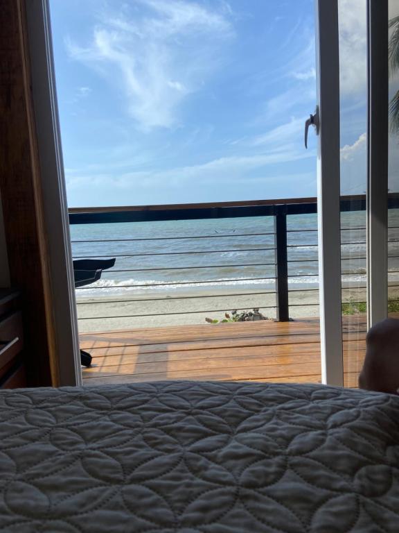 a bedroom with a bed and a view of the ocean at Ocean breeze Villas in La Ceiba