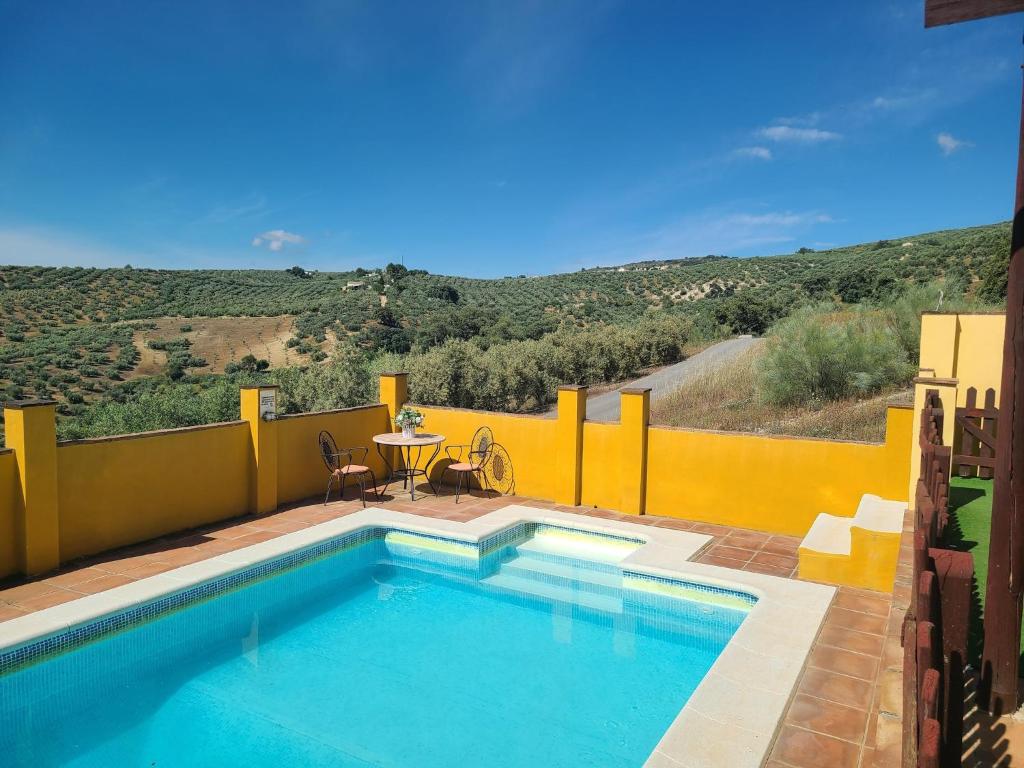 a swimming pool with a table and a table and chairs at Villa in Andalusia with Private Pool in Fuentes de Cesna