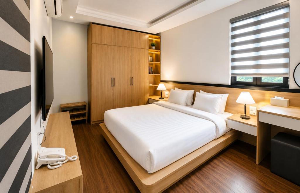 a bedroom with a bed and a desk and a television at Awesome Hanoi Hostel & Travel in Hanoi