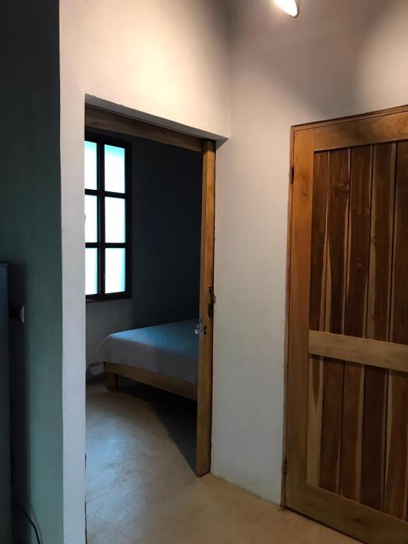 a room with a door and a bed and a window at Fuga Ecolodge casa de campo in Carara