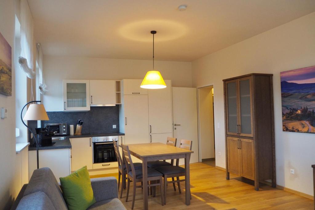 een woonkamer en een keuken met een tafel en een bank bij Mattone Aparthotel in Lanzenkirchen