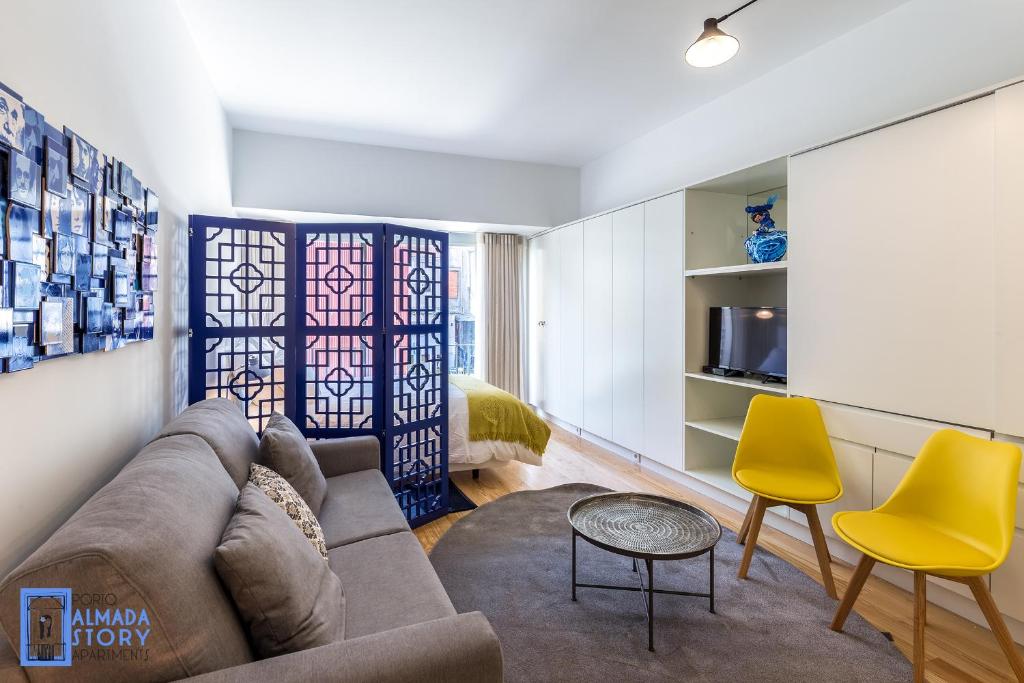 a living room with a couch and yellow chairs at Almada Story Apartments by Porto City Hosts in Porto