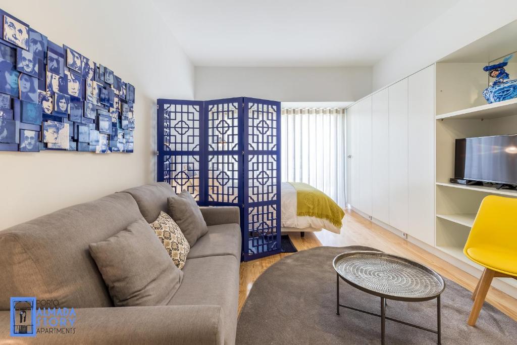 a living room with a couch and a tv at Almada Story Apartments by Porto City Hosts in Porto