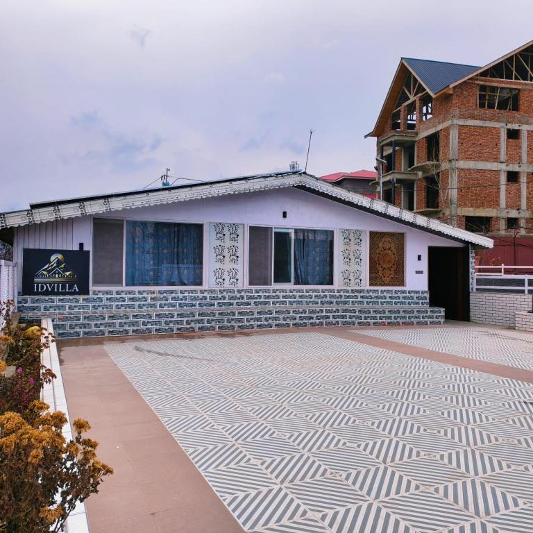 a building with a tiled courtyard in front of it at Id villa cottage in Tangmarg