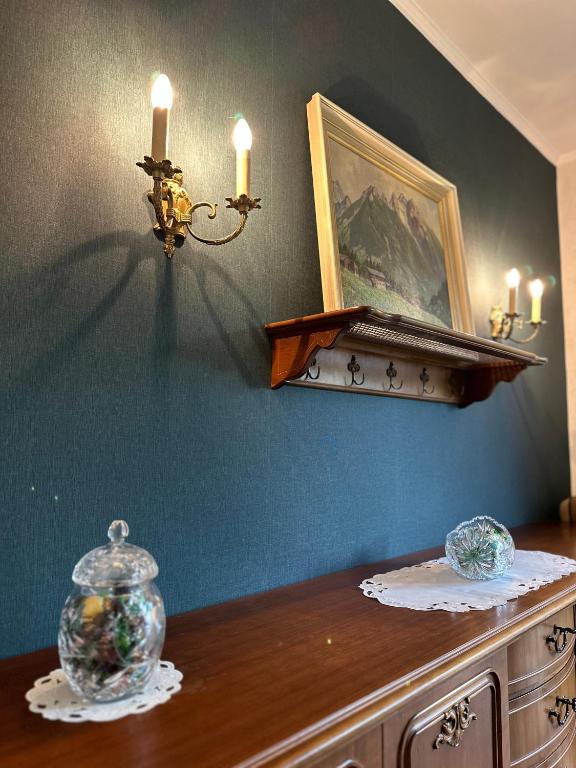 a table with a vase and candles on a wall at Schillings Häusken in Brilon