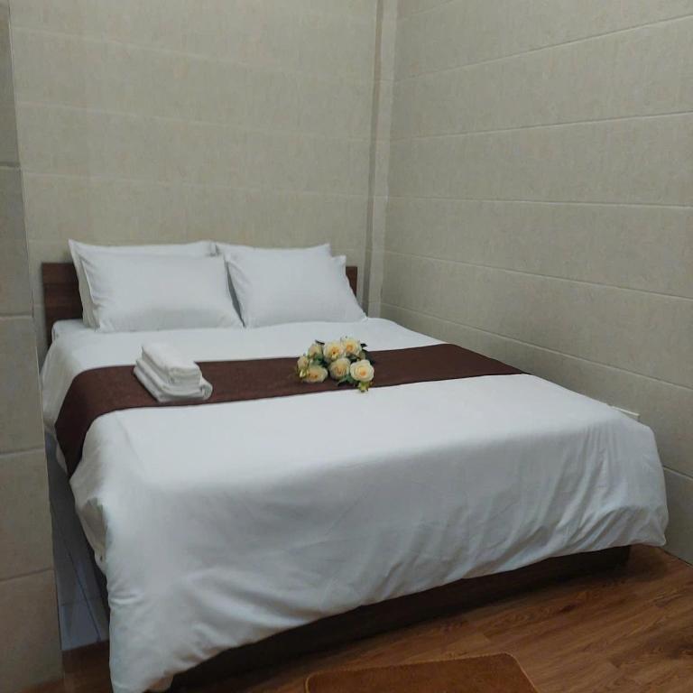a large white bed with flowers on top of it at Omeli homestay in Hanoi