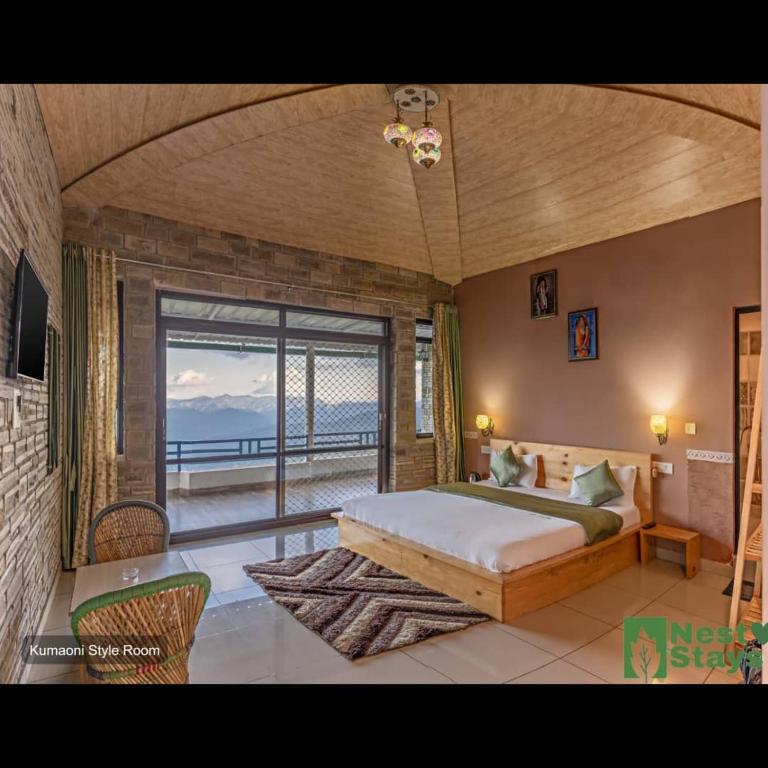 a bedroom with a large bed and a large window at Rudraa Himalayan Retreat in Hawālbāgh