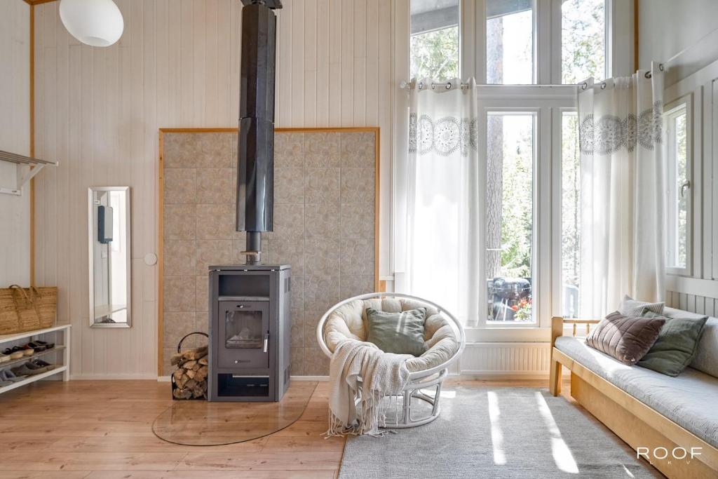 a living room with a couch and a chair at Villa Repovesi in Hillosensalmi