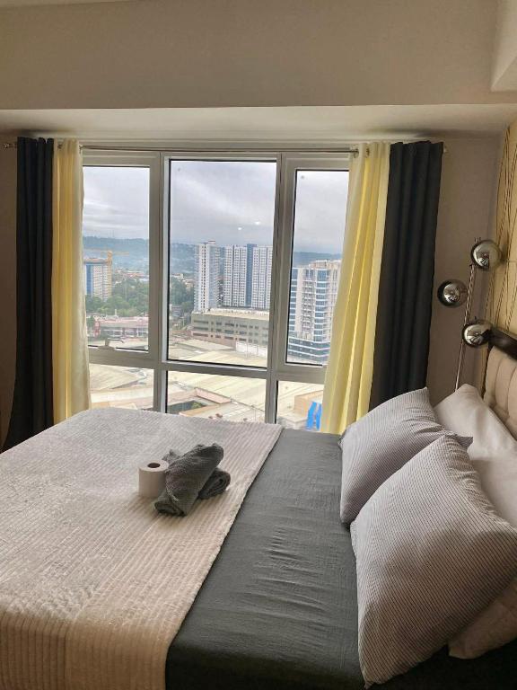a bedroom with a bird sitting on a bed with a window at Abreeza place tower 1 in Davao City