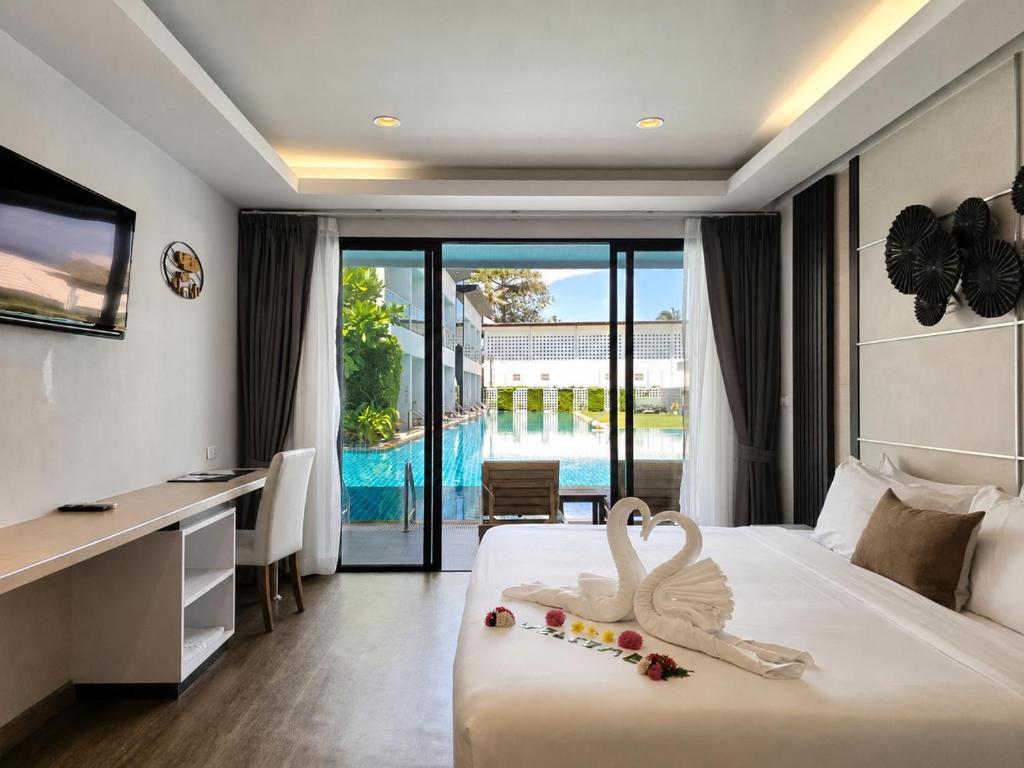 a hotel room with a bed with two swans on it at Chaolao Cabana Resort in Chao Lao Beach