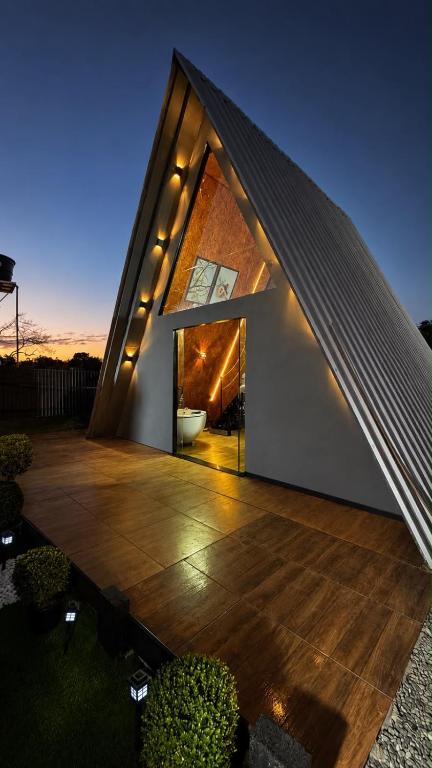a house with a triangular roof with a wooden deck at Chalé Queen in Brasília