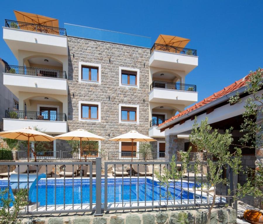 an image of a hotel with a swimming pool and umbrellas at Villa President 4 in Krimovice