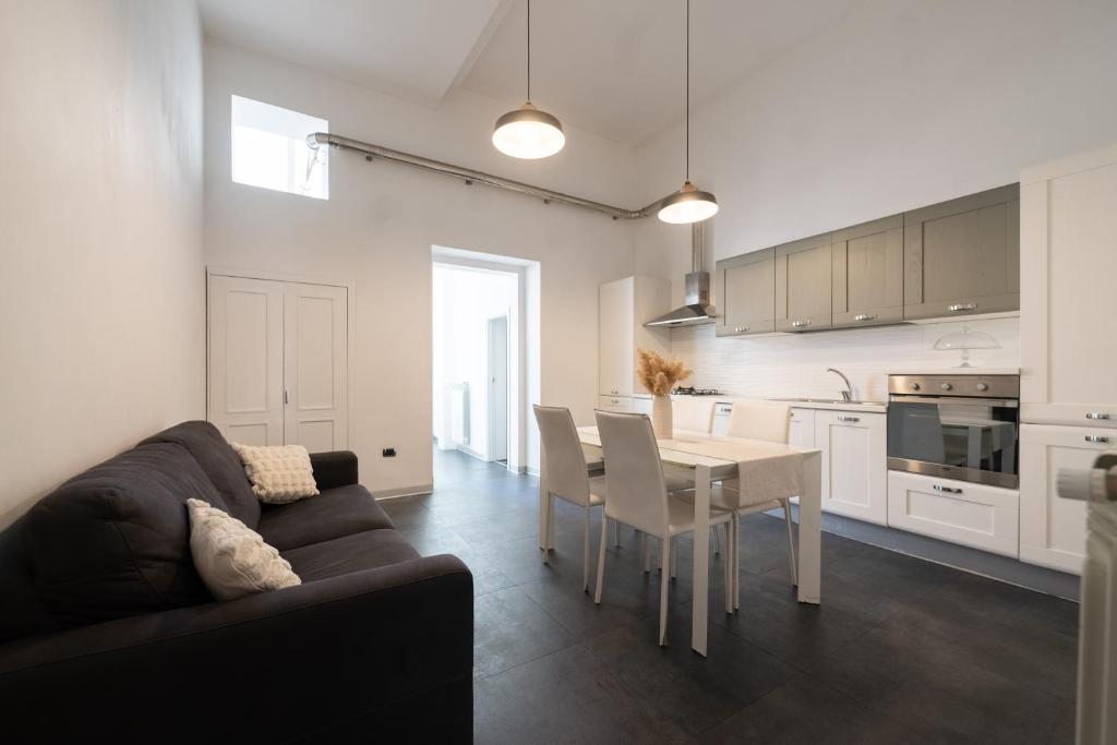 a living room and kitchen with a couch and a table at Dimora Altea in Taranto