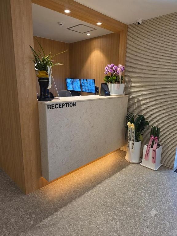 a reception desk in a lobby with potted plants at d hotel in Seoul
