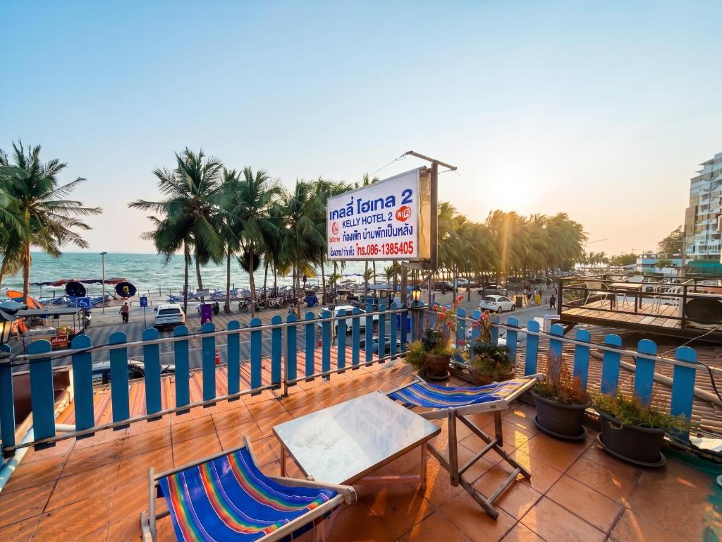 a balcony with chairs and a sign on a beach at Kelly Hotel Bangsean in Ban Laem Thaen