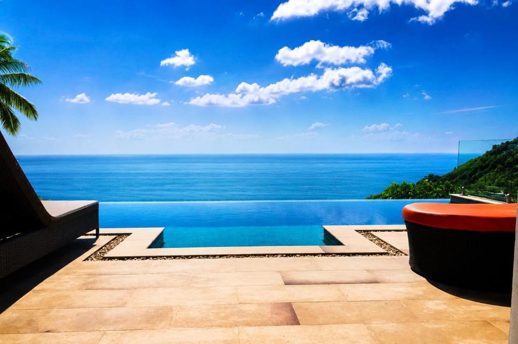 a swimming pool with a view of the ocean at Villa Jacuzzi Seaview Villa in Chaweng Noi Beach