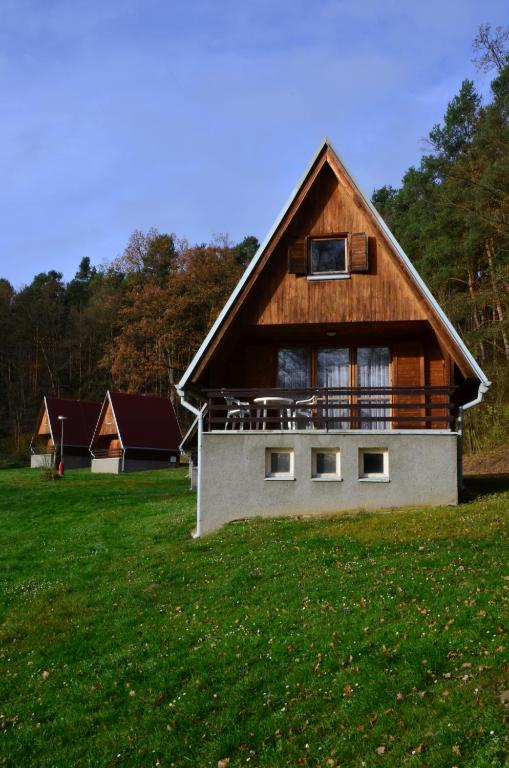 ein großes Holzhaus auf einem grünen Feld in der Unterkunft Barrandovská Zátoka in Kožlí u Orlíka