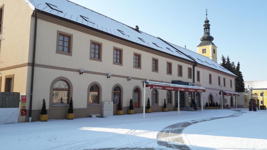 un gran edificio en una calle con nieve en el suelo en Hotel Amalia, en Ludbreg