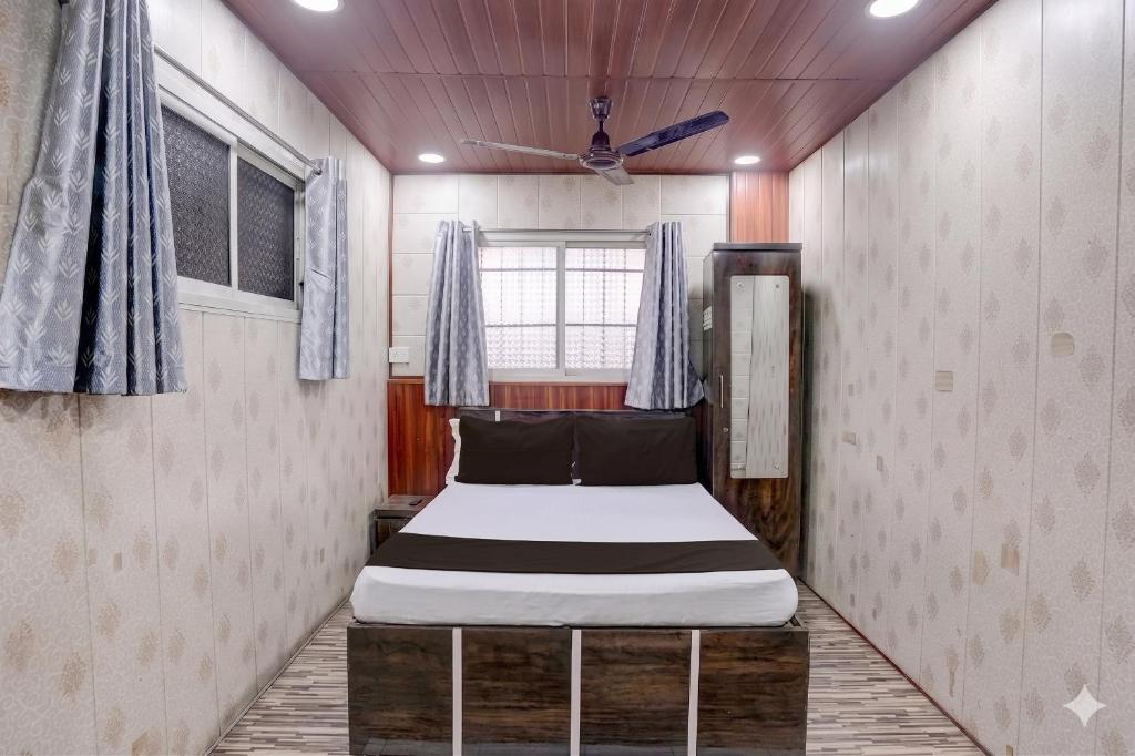 a small bedroom with a bed in a room at Hotel Garden Lodging And Boarding in Ulhāsnagar