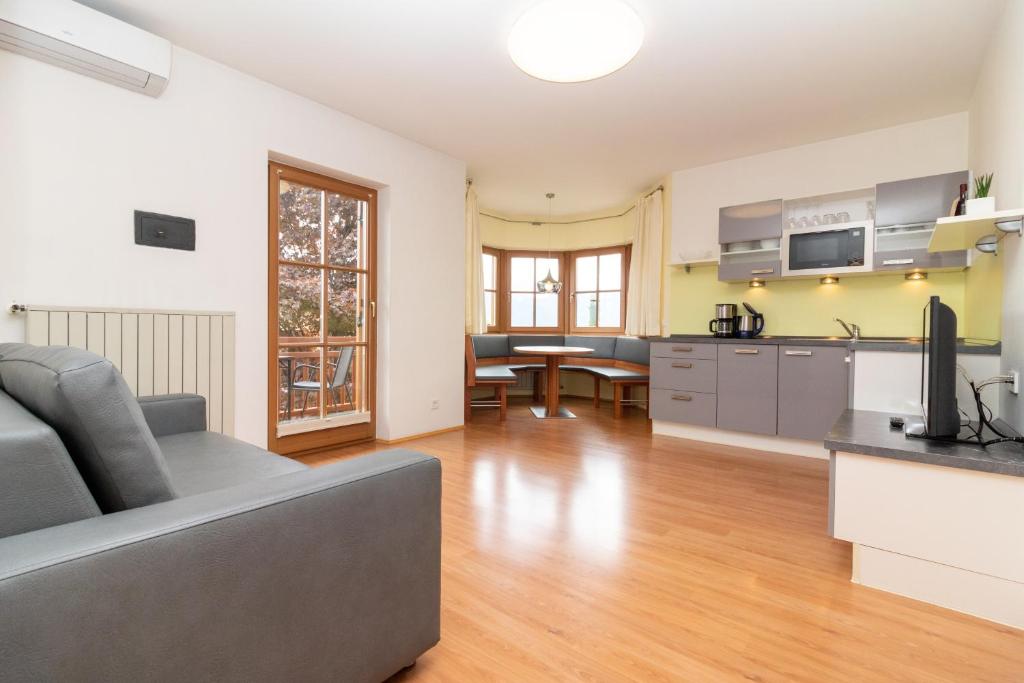 a living room with a couch and a kitchen at Stompferhof Erkerwohnung in Caldaro