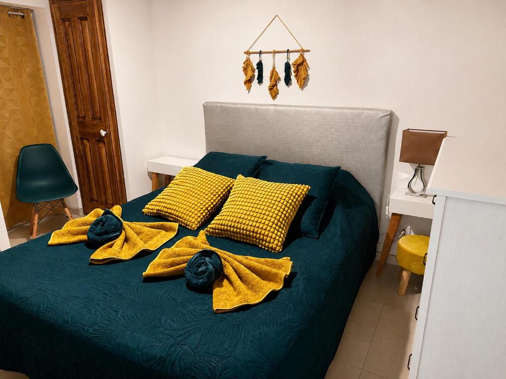 a bed with yellow blankets and yellow pillows on it at Gîte Le Jasmin in Le Thor