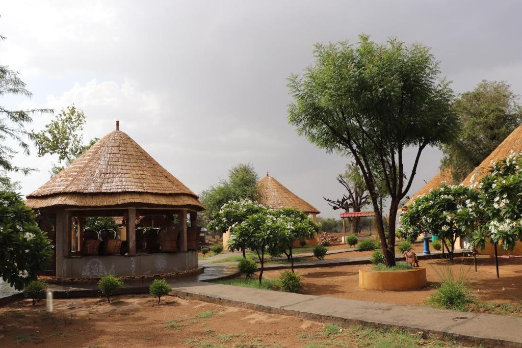a gazebo with a thatched roof in a park at Desert Nights in Mandāwa