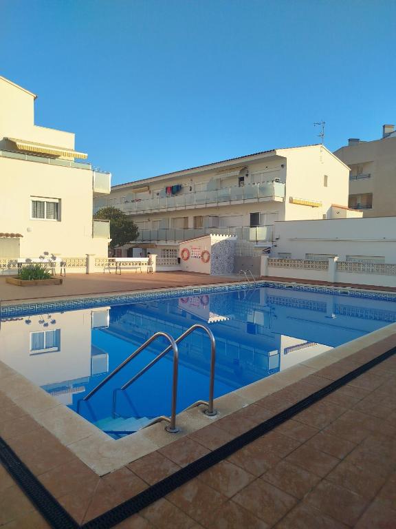 a swimming pool in front of a building at Apartamento Noenil in L'Estartit