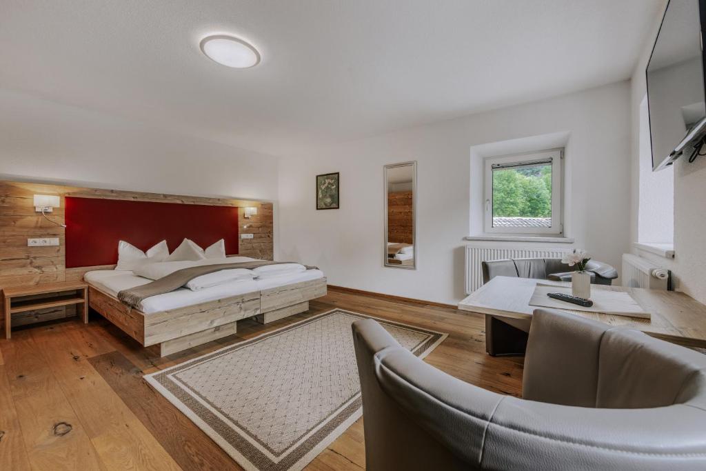 a bedroom with a bed and a table and chairs at Landhaus Waldesruh in Oetz