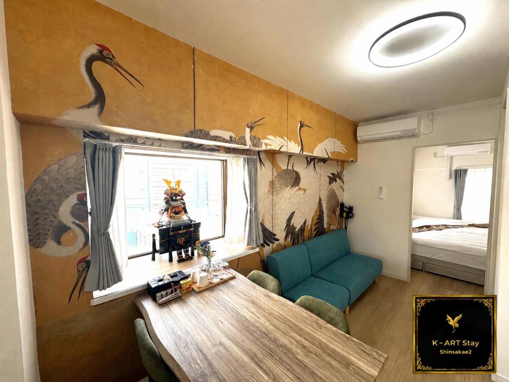 a room with a table and a bird mural on the wall at K-ART Stay Shinsakae2 in Nagoya