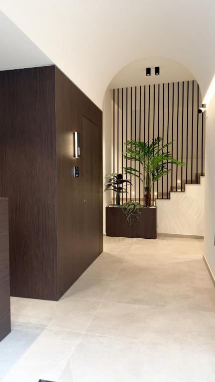 a hallway with a wooden door and a potted plant at Dimora degli archi in Terrasini