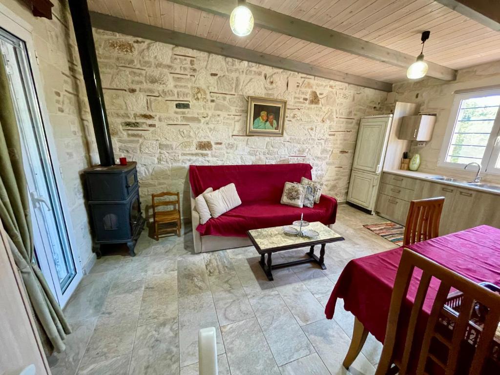 a living room with a red couch and a table at Mersini Village in Milonianá