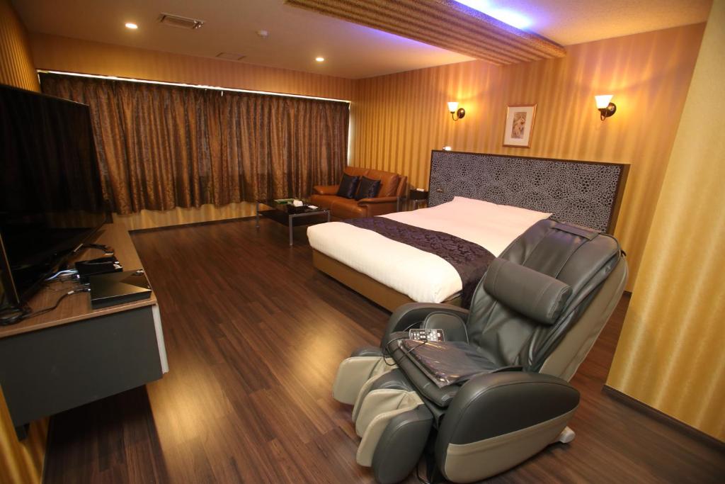 ein Hotelzimmer mit einem Bett und einem Stuhl in der Unterkunft Town Hotel 41 in Kanazawa