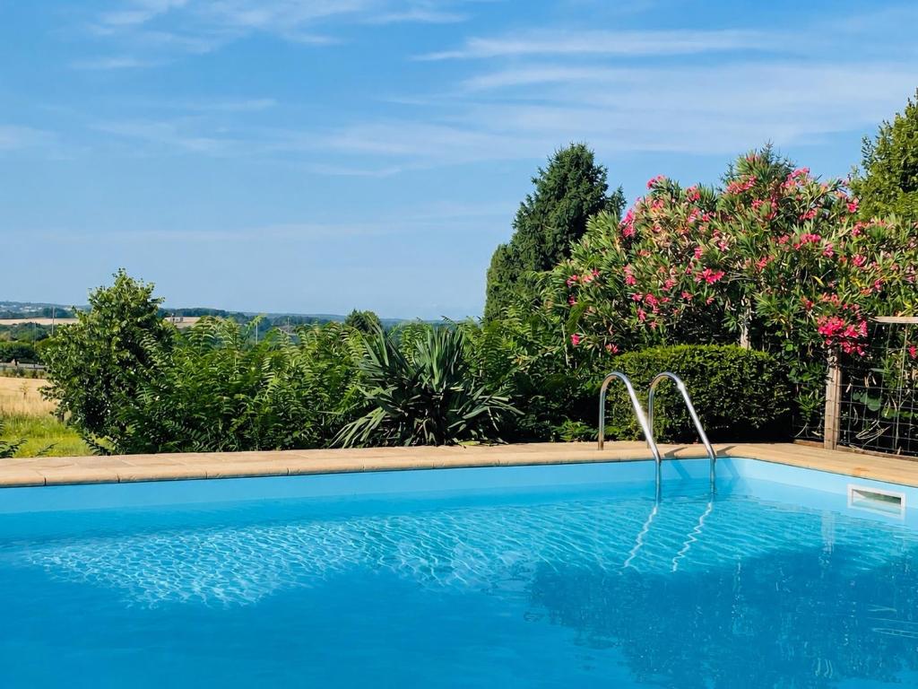 a swimming pool in a yard with trees at Domaine Voilà in Génis