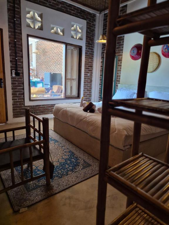 a bedroom with a bed and a large window at pesisircottage & stay in Selong Belanak
