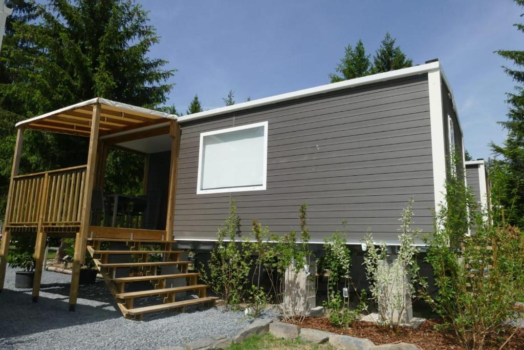 a tiny house with a large door and a porch at Sideschlee Chalet aan het water in Wintger
