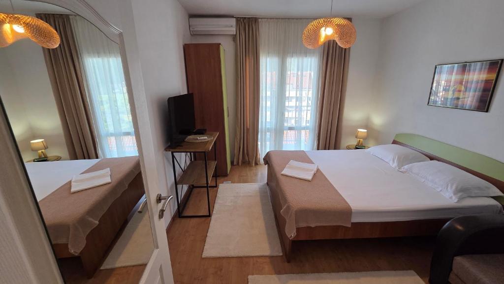 a hotel room with two beds and a television at Luna di mare 2 Igalo in Igalo