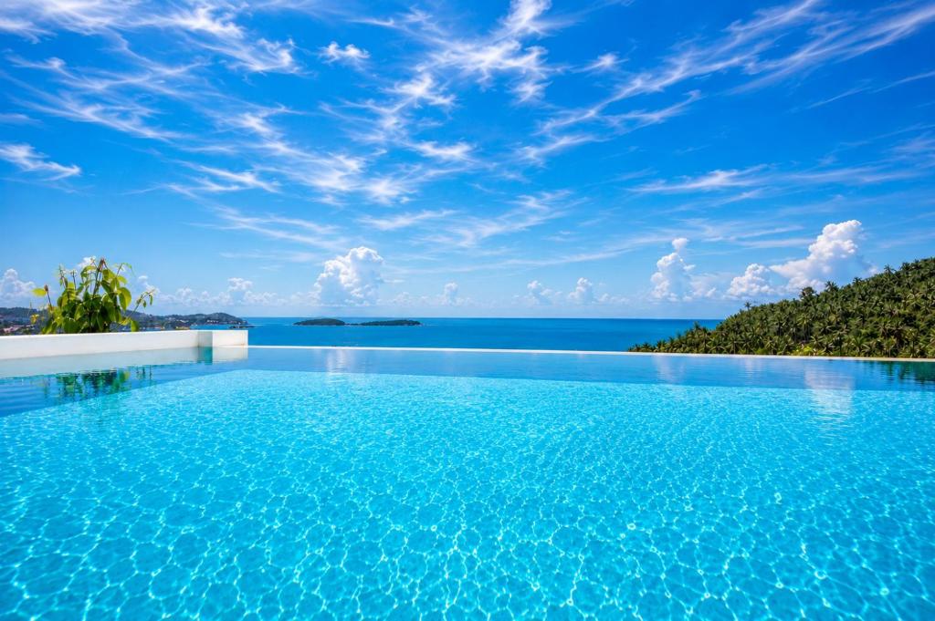 a swimming pool with a view of the ocean at INDIGO VILLA Samui in Koh Samui