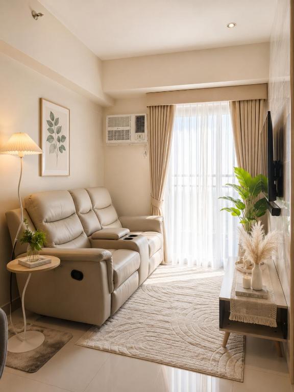 a living room with a couch and a table at Elegant 1BR Unit at Bryant Parklane, Capital Town near Malls and Tourist Destinations in Pampanga, Free Pool Access, Netflix, Prime Video in San Fernando