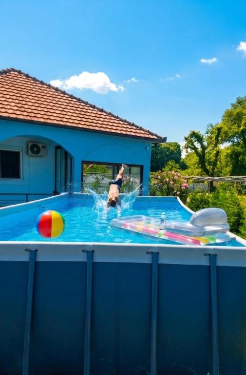 a man in a swimming pool with a ball at Hidden Oasis PeSa - Luxury Villa with Pool & Spa in Podgorica