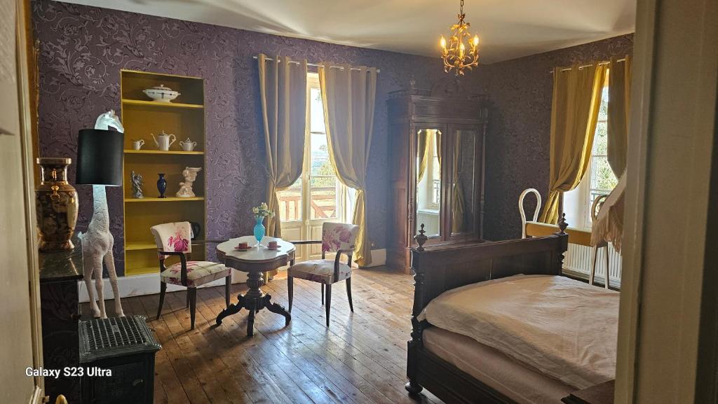 a bedroom with a bed and a table and a chair at Chambre Henri II in Fleuriel