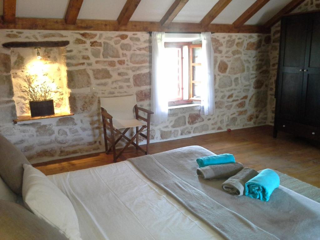 a bedroom with a bed with towels on it at Hvar Architect's House in Pitve