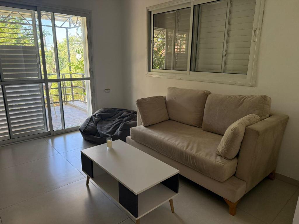 a living room with a couch and a coffee table at Hamsa Apartment in Menaẖemya